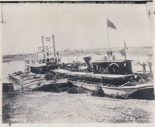 The Countess of Dufferin being transported up the Red River on a barge. It arrived in Winnipeg on October 8, 1877. The first locomtive was brought to Winnipeg by the CPR on a barge towed by the river steamer SS Selkirk, along with a caboose and six flat cars. The picture shows the locomotive on its barge moored at the foot of Lombard Street for inspection before being unloaded at St. Boniface. It was named Countess of Dufferin in honor of the wife of the governor-general. Winnipeg Free Press Archive fparchive Foote