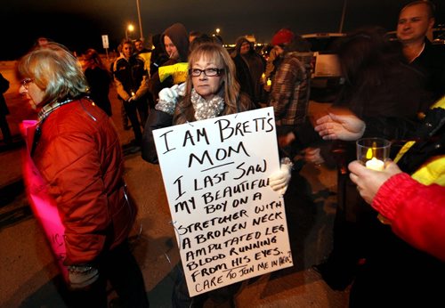 Connie Jaman wears a cryptic message at a vigil for her son at Grassmere and McPhillips Thursday. Brett Michael Yasinky died after a collision with an alleged drunk driver at the intersection. See story. 111110-(Phil Hossack / Winnipeg Free Press)