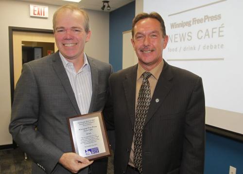 Winnipeg Free Press publisher Bob Cox gets an award from Exchange District Biz chair  Gord Holmes at the AGM. The award was given to the Free Press Cafe. November 24, 2011 (BORIS MINKEVICH/ WINNIPEG FREE PRESS)