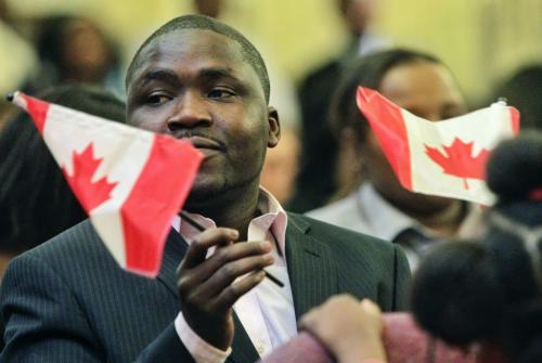 Chetima Mamadou Mai Moussa originally from Niger waves a flag after swearing the oath of citizenship at the Union Station Citizenship Court on Friday.  111125 Mike Deal / Winnipeg Free Press