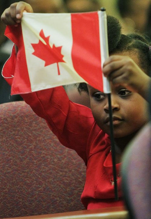 Divine Mugugu, 4, waves a flag after reaffirming the oath of citizenship at the Union Station Citizenship Court on Friday. Divine was born in Canada, but her mother, father and other members of her family became citizens at today's ceremony.  111125 Mike Deal / Winnipeg Free Press