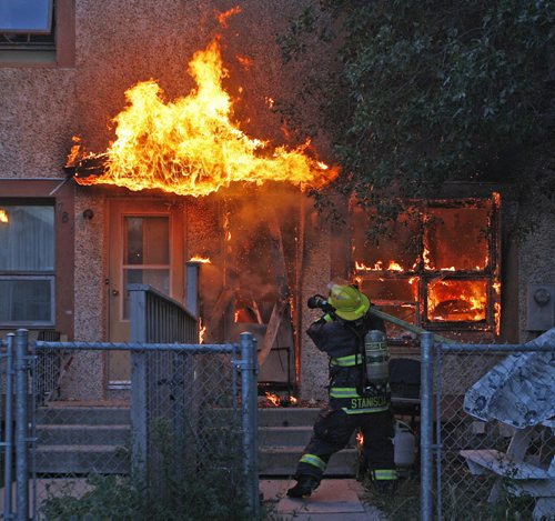 2nd Favourite  2011 POY - also to enter in NNA spot news - Wpg  Firefighter battles a blaze that was well involved  at a Wpg Housing Complex on St. Joseph St in Saint Boniface .The fire started in the kitchen  and spread rapidly  to the rear of the  housing unit . The male occupant  was lucky to  flee the  6:30 am fire without injury .The Fire was quickly put out by the WPG Fire Service  before it spread to other units .  - 2011 Pictures of the Year - POY  - PoV - - KEN GIGLIOTTI /  WINNIPEG FREE PRESS /  Aug 24  2011