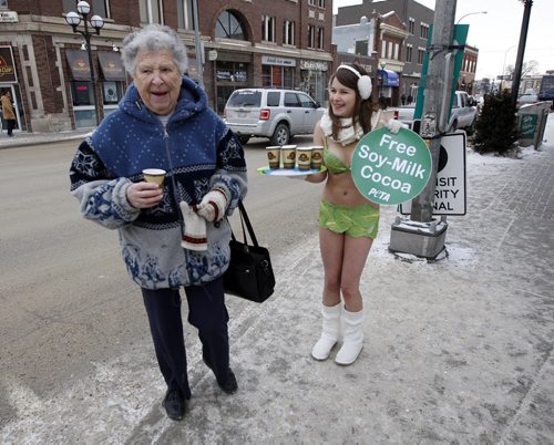 A bundled up Pattie Page  has a laugh and a free cup of hot Soy-Milk Cocoa  given out by "PETA 's Sexy Lettuce Lady"   ( PETA'S words )  , Emily Lavender  sports a bikini  and hot drinks  in Osborne Village  in - 12 degree temperatures to  encourage Winnipeger's to go vegan.  - 2011 Pictures of the Year - POY  - PoV - - KEN GIGLIOTTI /  WINNIPEG FREE PRESS / Jan 10  2011