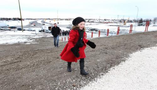 Five year old Abigail Cruise runs up the hill to the walking bridge over Chief Peguis Trail Friday after attending  the ribbon cutting ceremony Friday with her dad and brother officially opening the new extension of the trail. Dec 2, 2011 (Ruth Bonneville /  Winnipeg Free Press).