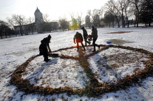 Occupy Winnipeg update. After cleaning out camp a small group of tents and occupiers hold tight on the grounds across from the Manitoba Legislature Building.  Some occupiers make a peace sign with some leaves left over. December 11, 2011 BORIS MINKEVICH / WINNIPEG FREE PRESS