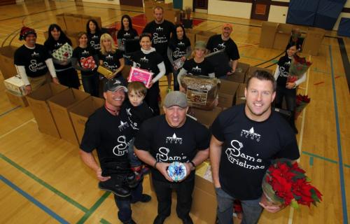 (front) Troy Westwood and his kid Trelan, coordinator of Sam's Christmas Jeff Fisher, and Doug Brown pose with all the helpers in Sam's Christmas gift program where 100 families recieved a hamper this year. They posed for a photo. December 11, 2011 BORIS MINKEVICH / WINNIPEG FREE PRESS