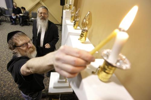 December 20, 2011 - 111220  -  Wayne Lefrovitz (L) and Rabbi Avrohom Altein light the first candle of a Menorah during a community celebration at the Jewish Learning Centre in Winnipeg, Tuesday, December 20, 2011.    John Woods /WINNIPEG FREE PRESS