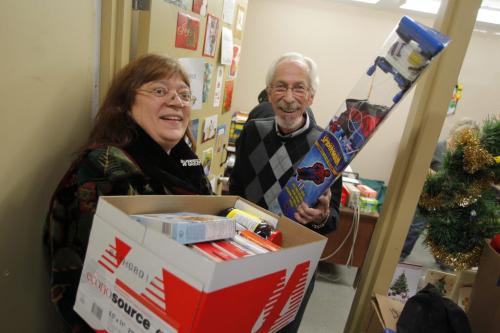 Kai Madson, right, gets a last minute donation from Maria Horvath at the Christmas Cheer Board. December 23, 2011 BORIS MINKEVICH / WINNIPEG FREE PRESS
