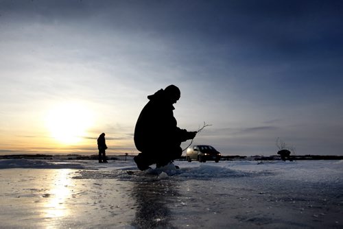 Brandon Sun A trio of friends from Brandon spend get the lines set up on on the ice on Lake Wahtopanah, near Rivers, Man., on Jan. 2, 2012. (Bruce Bumstead/Brandon Sun)