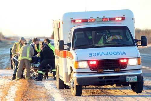 Brandon Sun Paramedics strap a patient to a stretcher after a single vehicle rollover on Highway 10 south of the Rapid City turnoff on Monday morning. One patient was taken to hospital with non-life-threatening injuries. Tim Smith/Brandon Sun)