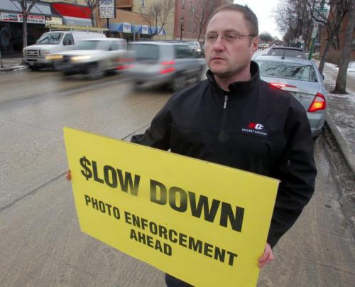 Todd Dube poses with one of his signs to warn motorist about photo radar. January 10, 2012 BORIS MINKEVICH / WINNIPEG FREE PRESS