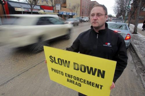 Todd Dube poses with one of his signs to warn motorist about photo radar. January 10, 2012 BORIS MINKEVICH / WINNIPEG FREE PRESS