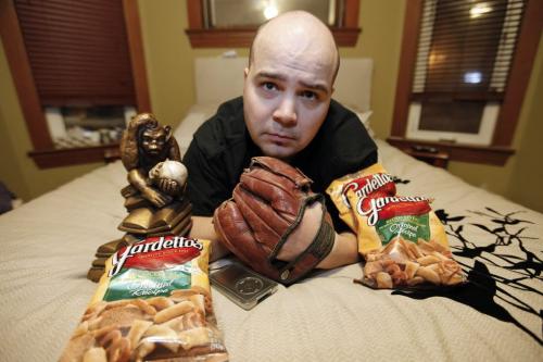 January 17, 2012 - 120117  -  Jared McKetiak, station manager at UMFM, is photographed for My Stuff in his home with his stuff; pretzels, iPod, a t-shirt, his dad's old baseball glove, his bed and a replica of Hugo Rheinhold's Monkey With Skull, aka the Darwin Monkey Tuesday January 17, 2012.    John Woods / Winnipeg Free Press  ***For Africa edition***