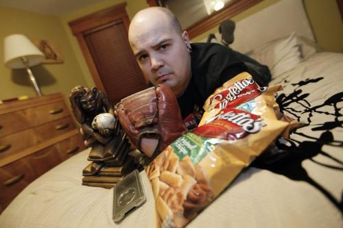 January 17, 2012 - 120117  -  Jared McKetiak, station manager at UMFM, is photographed for My Stuff in his home with his stuff; pretzels, iPod, a t-shirt, his dad's old baseball glove, his bed and a replica of Hugo Rheinhold's Monkey With Skull, aka the Darwin Monkey Tuesday January 17, 2012.    John Woods / Winnipeg Free Press