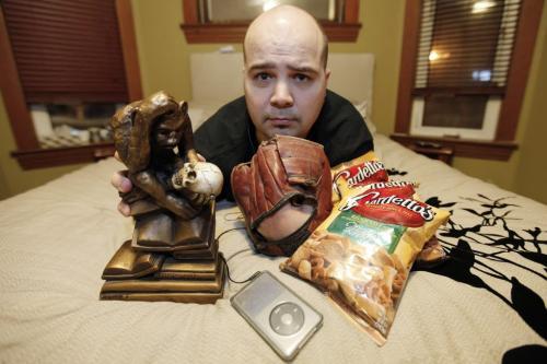January 17, 2012 - 120117  -  Jared McKetiak, station manager at UMFM, is photographed for My Stuff in his home with his stuff; pretzels, iPod, a t-shirt, his dad's old baseball glove, his bed and a replica of Hugo Rheinhold's Monkey With Skull, aka the Darwin Monkey Tuesday January 17, 2012.    John Woods / Winnipeg Free Press