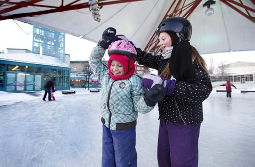 Sisters Anika Price - 9 yrs (pink hat) and Kaily - 11yrs skate are all smiles as they twirl each other around under the Forks skating canopy Friday afternoon. Standup picture.   Jan 20, 2012 (Ruth Bonneville /  Winnipeg Free Press)