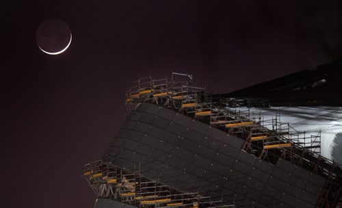 The first New Moon of 2012 peers hangs over the Canadian Museum for Human Rights construction Tuesday night. Weather? STAND-UP. January 24, 2012 - (Phil Hossack / Winnipeg Free Press) CMHR
