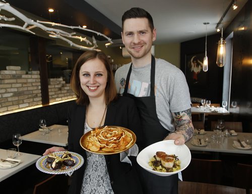 Restaurant Review of Segovia Tapas Bar and Restaurant.  Co-owners Carolina Konrad with stuffed dates and Patatas Bravas  with Adam Donnelly with seared scallops.    Marion Warhaft story    (WAYNE GLOWACKI/WINNIPEG FREE PRESS) Winnipeg Free Press Jan. 25 2012