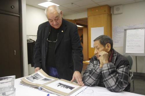 Residential School Survivors call for a review from officials. Press conference at the Place Louis Riel's Hudson Room. Ted Quewezance, lead society spokesman with residential survivor, looks through some photos from Crowfoot School, a residential school Roy Littlechief, sitting right, went to. Littlechief is from Siksika Nation south east of Calgary, Alberta. REPORTER: Alexandra Paul  February 2, 2012 BORIS MINKEVICH / WINNIPEG FREE PRESS