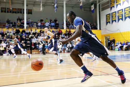 Brandon Sun 04022012 Donovan Gayle #8 of the Brandon Bobcats dribbles the ball up court  during university basketball action against the Lethbridge Pronghorns at the Brandon University Gymnasium on Saturday evening.  (Tim Smith/Brandon Sun)