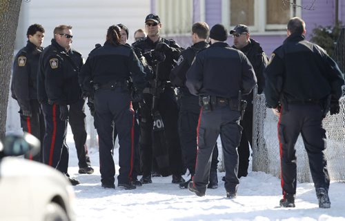 Winnipeg Police Tactical Response Unit meet after entering a house on Pritchard Avenue near Alrington Street, Saturday, February 18, 2012. (TREVOR HAGAN/WINNIPEG FREE PRESS)