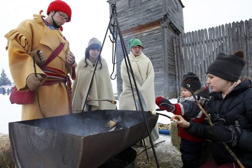 At right, Melissa Boothroyd and her son River bake bannock over the fire with interpreters from left Alex Quesnel, Sara Clement and Justine Orum part of Festival du Voyageur by Fort Gibraltar in Voyageur Park Thursday.The festival continues till Sunday. see guide at photo desk for more info if needed.   (WAYNE GLOWACKI/WINNIPEG FREE PRESS) Winnipeg Free Press Jan. Feb 23 2012