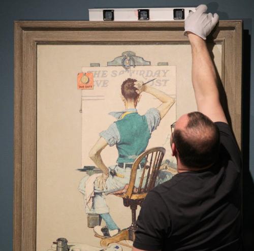Vitaliy Yatsevych a WAG staff member, straightens the final painting for the show as the Winnipeg Art Gallery puts the final touches on its spring blockbuster, American Chronicles: The Art of Norman Rockwell. 120229 February 29, 2012 Mike Deal / Winnipeg Free Press
