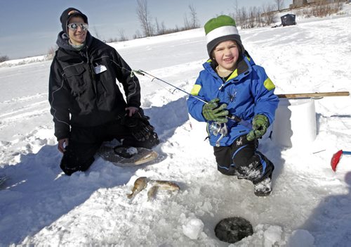 Fun Family Fishing Day at FortWhyte Alive Volunteer Adam Cox (left) with some bait that was caught earlier in the week with Josh Gadza, 6, who won a fishing rod while learning to ice fish for the first time.  See Geoff Kirbyson story 120303 - Saturday, March 03, 2012 -  (MIKE DEAL / WINNIPEG FREE PRESS)