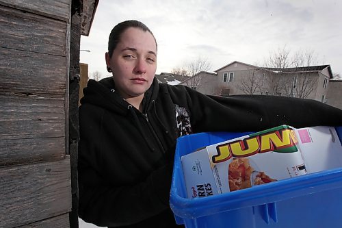 Meghan Halfyard holds her recyling bin that was full of her weeks worth of recyling and set out for Friday's pick up but was found discarded with her recyling strewn all over her backlane. See Melissa Martin Story. (Ruth Bonneville / Winnipeg Free Press)