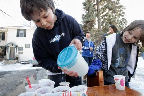 Luki Bohm, 10, pours some lemonade for a customer while his brother Yannick, 8, watches. The brothers have been serving a steady stream of customers from a stand in their yard in Wolseley. 120310 March 10, 2012 Mike Deal / Winnipeg Free Press