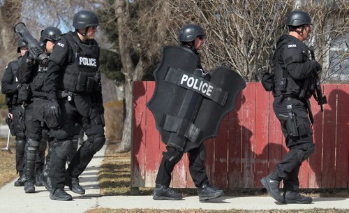 815 Government EK, a city police Tactical team marches away from a house they raided earlier this morning as part of "Operation Flatlined". See MacIntyre's tale. March 16, 2012 - (Phil Hossack / Winnipeg Free Press)