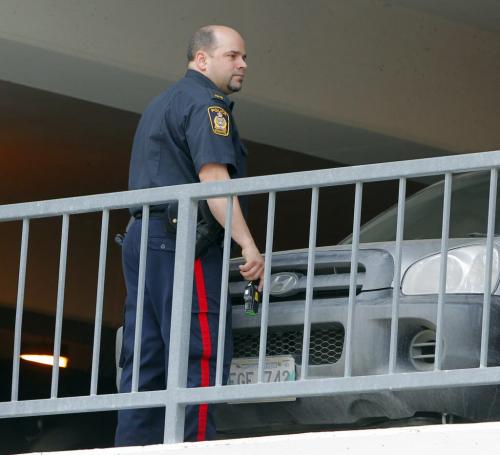 A police officer with a tazer gun protects his area against a coyote that was trapped on the second floor of a parkade on Albert Street.  March 19, 2012  BORIS MINKEVICH / WINNIPEG FREE PRESS