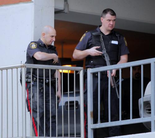 Armed police officers stand on guard as a coyote was trapped on the second floor of a parkade on Albert Street this afternoon.  March 19, 2012  BORIS MINKEVICH / WINNIPEG FREE PRESS