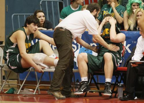 March 19, 2012 - 120319  -   A dejected John Taylor Pipers player is consoled by the coach after being defeated by the Garden City Fighting Gophers in the 2012 AAAA High School Basketball championship at University of Winnipeg Monday March 19, 2012.    John Woods / Winnipeg Free Press