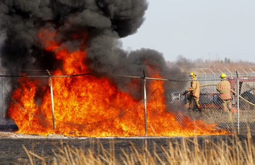 A grass fire spread across to some plastic piping in the yard of Geo Source Specialties at 8141 Wilkes Avenue. Fire crews from Winnipeg and Headingley were on scene as well as RCMP. Lots of smoke. March 22, 2012  BORIS MINKEVICH / WINNIPEG FREE PRESS