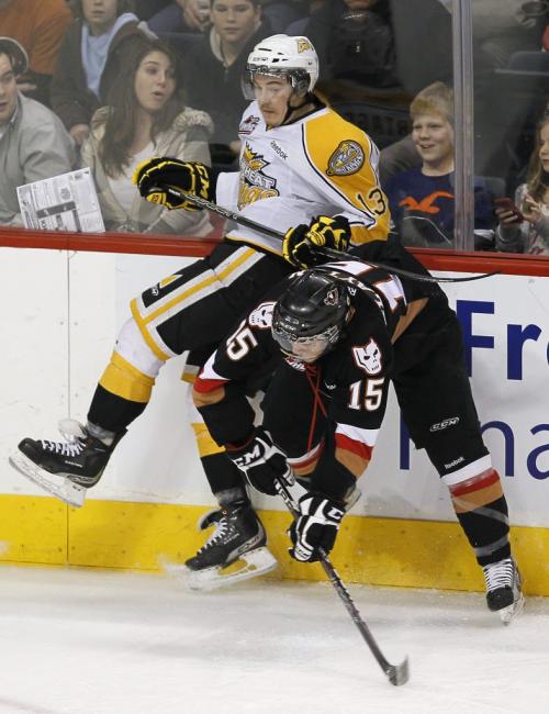 March 27, 2012 - 120327  -  Brandon Wheat Kings' Alessio Bertaggia (18) is checked by Calgary Hitmen's Chase Clayton (15) in the first period of their WHL playoff game in Winnipeg Tuesday March 27, 2012.    John Woods / Winnipeg Free Press