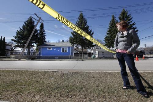 March 31, 2012 - 120331  -  From behind police tape Melanie San Filippo looks at her home which is threatened by a damaged hydro pole Saturday March 31, 2012. Melanie San Filippo was told to leave her home after a hydro pole was struck by a speeding car. John Woods / Winnipeg Free Press