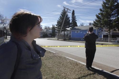 March 31, 2012 - 120331  -  From behind police tape as her husband takes photos of the damage Melanie San Filippo looks at her home which is threatened by a damaged hydro pole Saturday March 31, 2012. Melanie San Filippo was told to leave her home after a hydro pole was struck by a speeding car. John Woods / Winnipeg Free Press