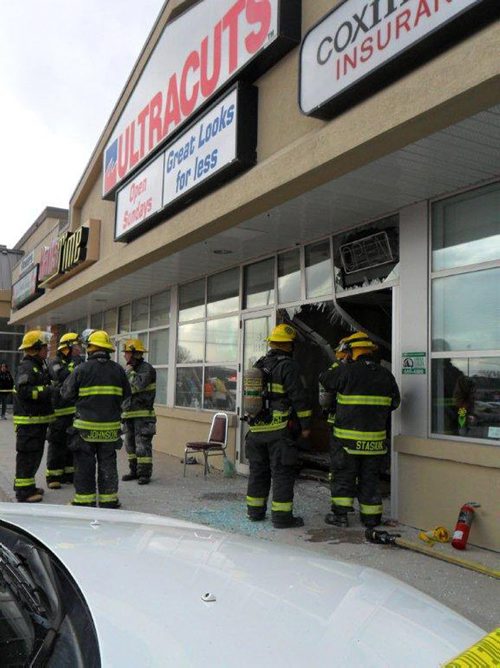Firefighters assess and discuss their extrication options after a vehicle tore through Ultracuts at Cavalier and Portage late Saturday afternoon. Kendall Wiebe was reportedly pinned to a wall when the vehicle came to a stop. See Carol Sanders story. April 7, 2012. (CAROL SANDERS / WINNIPEG FREE PRESS)