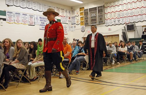 STDUP - Citizenship Court was held at Vincent Massey Collegiate , the newcomers  were  sworn in  by Judge Art Miki , in pic he is accompanied into the gym assembly  of VMC students by RCMP Sgt. Brad Miner , 51 new citizens fronm 13 countries were sworn in at the special cerimony  KEN GIGLIOTTI  / WINNIPEG FREE PRESS  / April 18 2012
