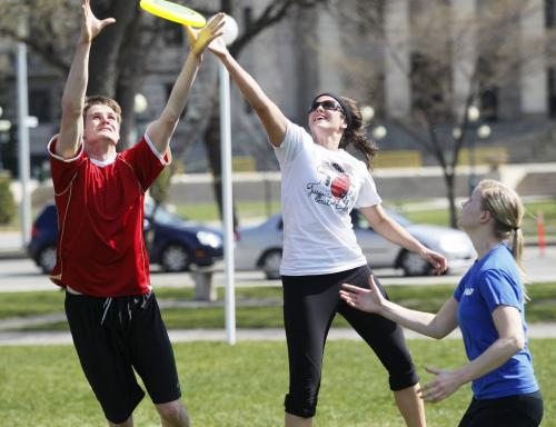 April 22, 2012 - 120422  - Marc Ranson and Sydney Hammond go up for a frisbee as their friend Sheila Felsch looks on during a game of ultimate at Memorial Park Sunday, April 22, 2012.   John Woods / Winnipeg Free Press
