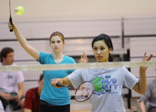 Brandon Sun 24042012 Katherine Lee (R) serves as partner Olivia Pieroni waits for the return during the doubles semifinals of the city high school badminton championships at VMHS on Tuesday evening. Lee and Pieroni are Vincent Massey High School students. (Tim Smith/Brandon Sun)