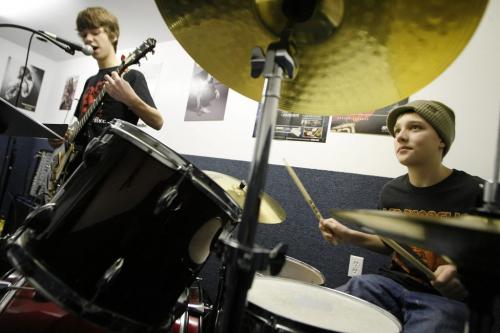 John Woods / Winnipeg Free Press / February  3 2007 - 070203  - Jared Kist (14) sings and plays guitar while Eric Brommell (14) plays drums in the rock band class at Spirit Music Saturday  Feb 3/07.