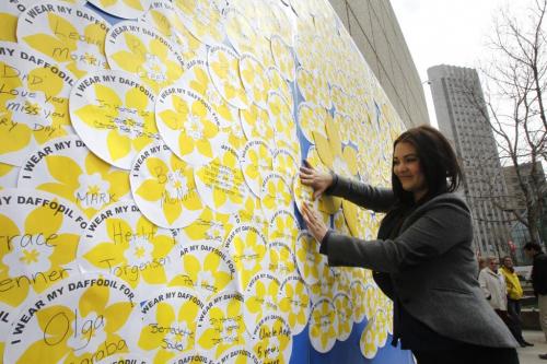 Vanessa Kunderman, a cancer survivor and whose father died from cancer attaches a message on the giant daffodil tribute wall for her supportive mother  and " fortress" Lorraine Shapera at an event held at noon in the ¤201 Portage Courtyard as the final event of Daffodil Month. The noon event included a video,  a speech by Vanessa and others by the tribute wall showing over 400 personal messages about who and why Manitobans are wearing their daffodil pin of the Canadian Cancer Society. ¤  (WAYNE GLOWACKI/WINNIPEG FREE PRESS) Winnipeg Free Press  April 27