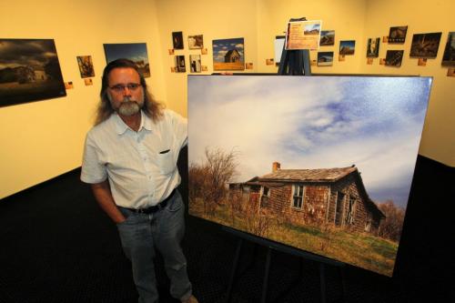 Photographer Wayne Benedet poses for a photo with some of his work. Landscapes featuring abandon houses. Photo taken at the Mennonite Heritage Village Museum gallery. May 3, 2012  BORIS MINKEVICH / WINNIPEG FREE PRESS