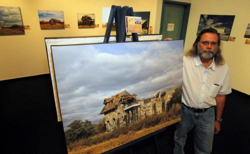 Photographer Wayne Benedet poses for a photo with some of his work. Landscapes featuring abandon houses. Photo taken at the Mennonite Heritage Village Museum gallery. May 3, 2012  BORIS MINKEVICH / WINNIPEG FREE PRESS