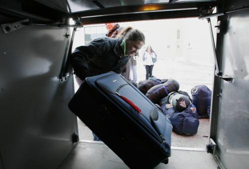 John Woods / Winnipeg Free Press / February - 070209  - Jessie Greenwood, U of Manitoba student and one of fifty people going to New Orleans to build a house for Habitat for Humanity, loads her luggage into the luggage compartment of a bus at the U of MB. Friday February 9/07.  The group set out today on the thirty hour bus ride to spend their spring break helping build a home.