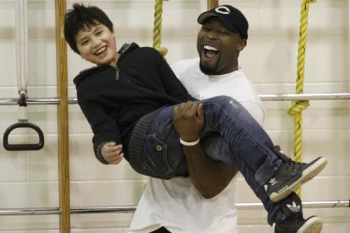 Chicago Bears defensive end Israel Idonije lifts a student (name withheld, on orders of principal) during a game of octopus tag at Sister MacNamara School on Friday. Idonije was named the schools principal for a day and participated in gym classes with the students throughout the morning. This event was in conjunction with the Israel Idonije Foundation First Down Attendance program, which encourages students to maintain regular school attendance and overall high achievement. May 04, 2012. SARAH O. SWENSON / WINNIPEG FREE PRESS