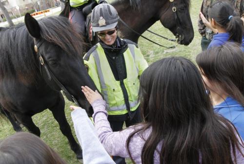 SUNDAY XTRA - Constable Sherry Blunden holds the reins of while children from Wi Wabigooni School pet Amaro in Central Park on Friday.  Blunden and her partner Constable Anna Proskurnik, who rides Titus, are the only mounted members of the Winnipeg police service. May 04, 2012. SARAH O. SWENSON / WINNIPEG FREE PRESS