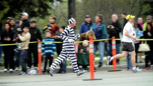A participant dressed as a prisoner runs past the footbridge at around the six mile mark.  Around 1,900 people took part in the Winnipeg Police Service half-marathon this morning. The eighth annual event started and finished at Assiniboine Park and is expected to raise about $100,000 for Cops for Cancer. Organizers had initially expected about 2,500 participants, but said the weather may have dissuaded some people from coming out. See Jen Skerritt story 120506 May 06, 2012 Mike Deal / Winnipeg Free Press